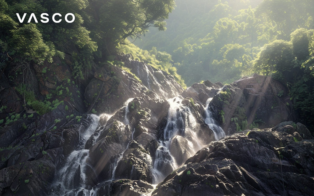 Una cascada rodeada de un exuberante bosque verde a la luz del sol.