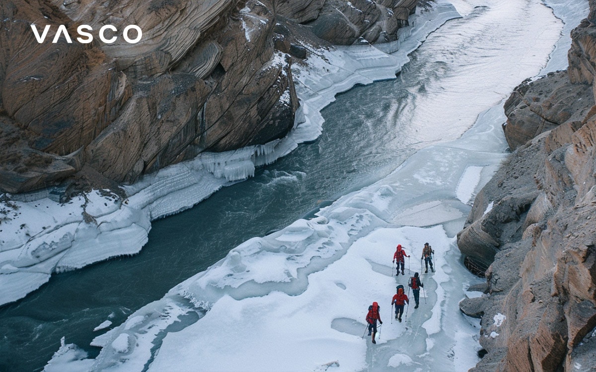 Grupo de montañistas caminando por un rio congelado a través de un cañón nevado 