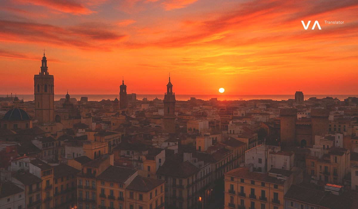 Vista aérea de Valencia, España, al amanecer, con torres históricas y tejados bajo un espectacular cielo naranja.