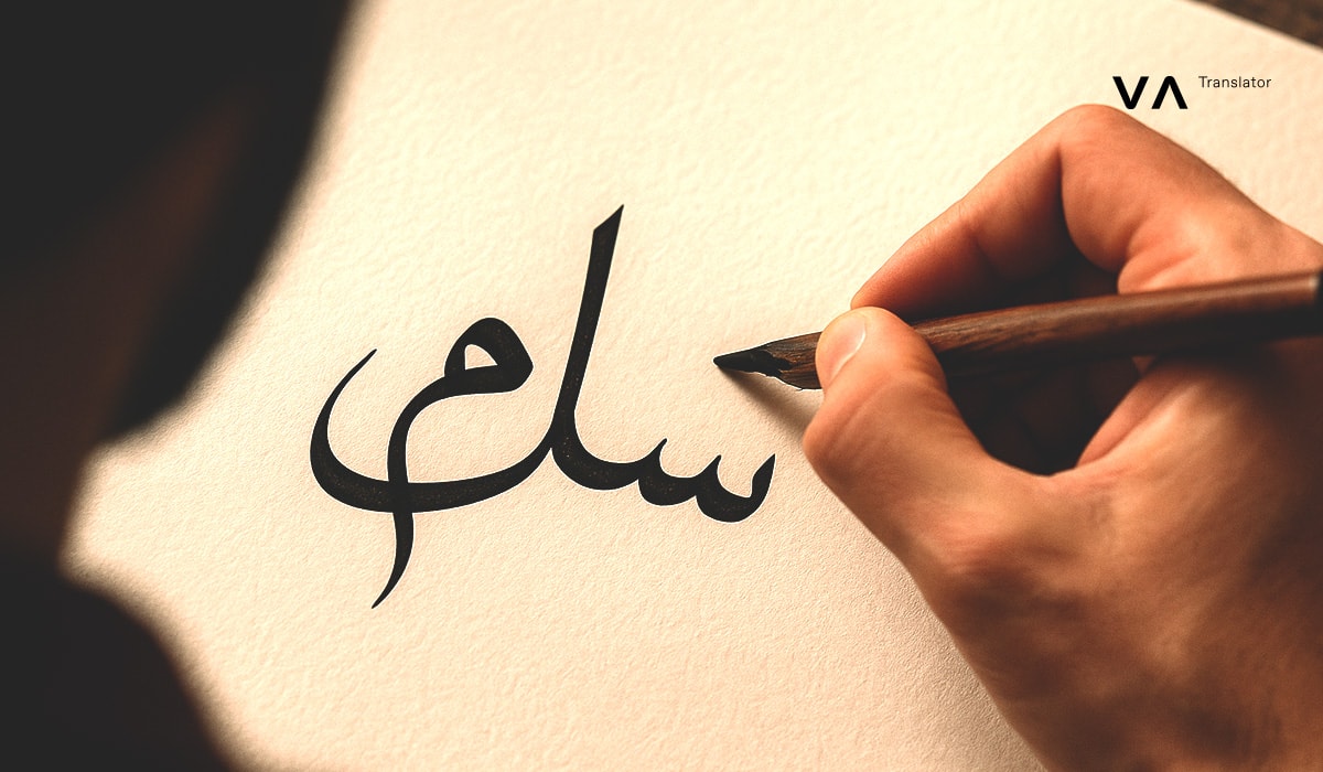 Una persona está escribiendo la palabra «salam» en árabe con una pluma sobre una hoja de papel de color crema, mientras que el logotipo de Vasco aparece en la esquina superior derecha.
