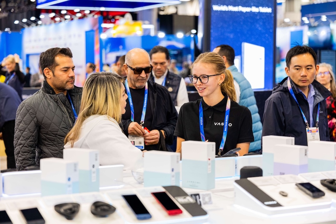 CES 2026 Un grupo de personas sonrientes conversan en el stand de Vasco Electronics en el CES 2026.