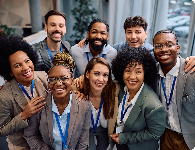 Un grupo sonriente de trabajadores de oficina que representan diversas culturas.