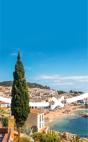 Vista de la costa y la localidad cercana de Fang Aventura, en Girona, con acantilados escarpados, aguas azules y un entorno urbano pintoresco.