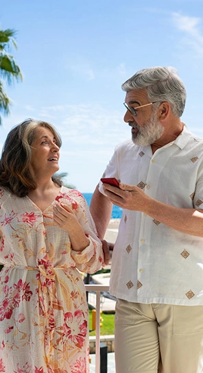 Dos personas mayores con dispositivos VA V4 en la mano, hablando entre ellas y mostrando cinco opciones diferentes de velocidad de reproducción.