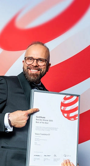 El director ejecutivo de Vasco Electronics sostiene el premio Red Dot, mostrando los dispositivos galardonados.