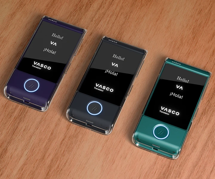 Tres traductores M4 puestos sobre una mesa dentro de fundas de silicona transparentes de tres colores diferentes, con las pantallas encendidas mostrando el logotipo de Vasco y los botones LED iluminados.